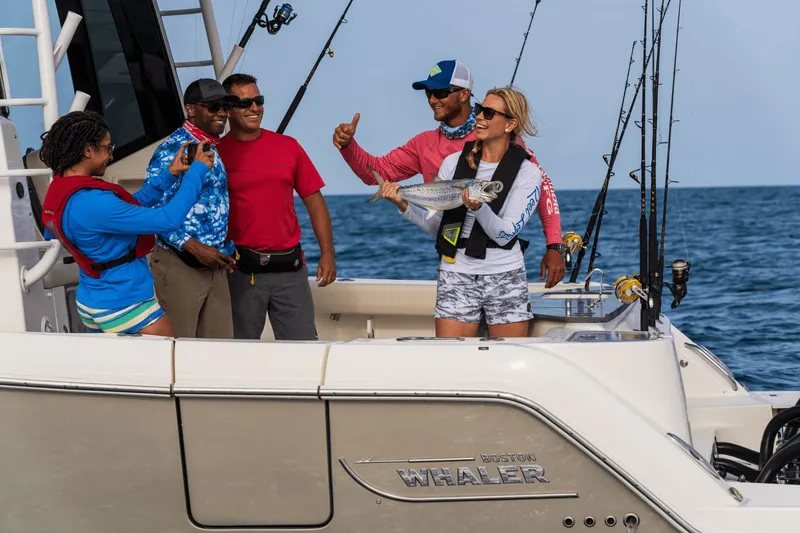 Slide: The Image of A group of people posing on a boat with a caught fish. - 29