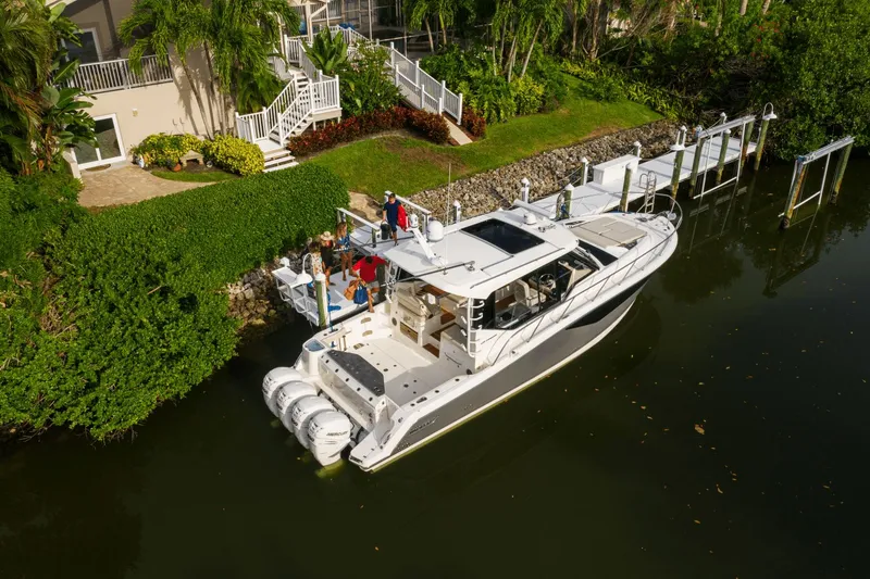 Slide: The Image of 2026 Boston Whaler 405 Conquest docked, surrounded by lush greenery. - 16