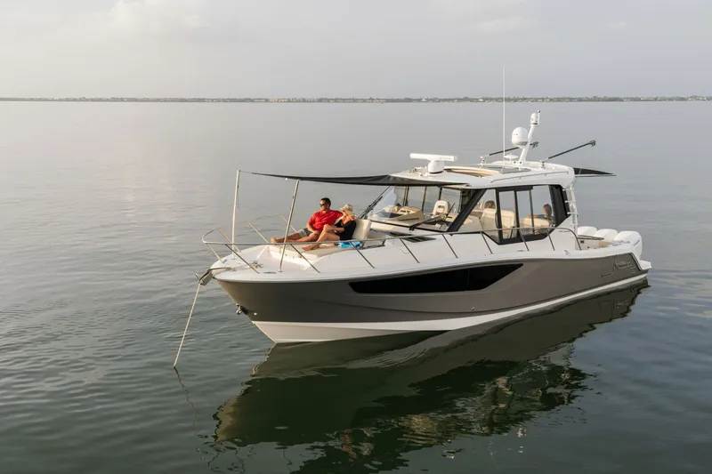 Slide: The Image of A 2026 Boston Whaler 405 Conquest on calm water with people relaxing on board. - 20