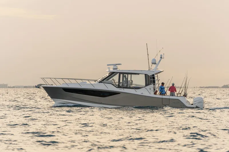 Slide: The Image of A 2026 Boston Whaler 405 Conquest on calm water with two people on board. - 31