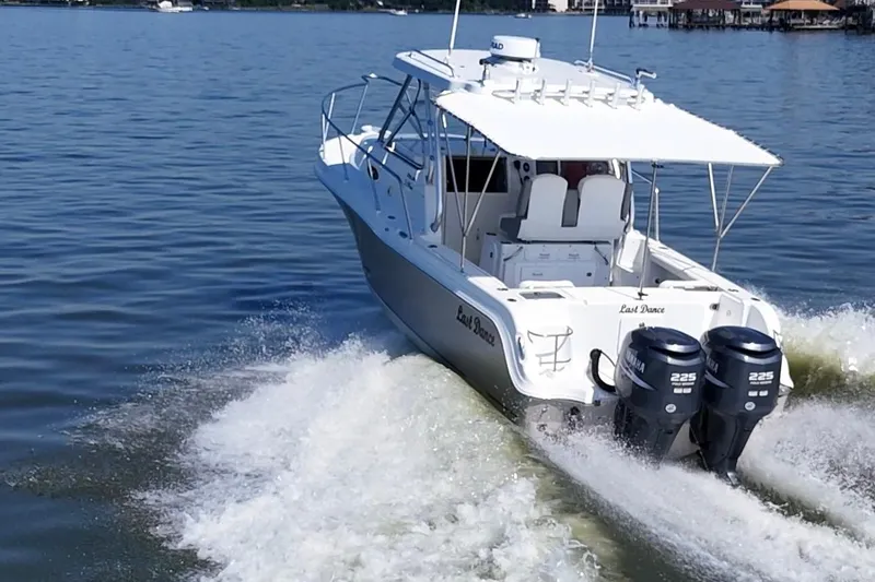 Slide: The Image of 2007 Polar 2700 Walkaround boat cruising on a calm lake with dual Yamaha engines. - 10