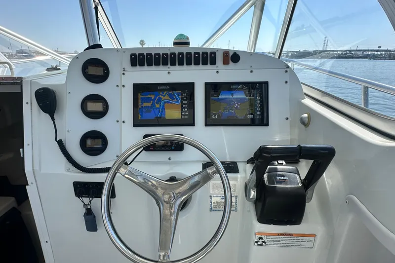 Slide: The Image of 2007 Polar 2700 Walkaround boat dashboard with steering wheel and navigation screens. - 19