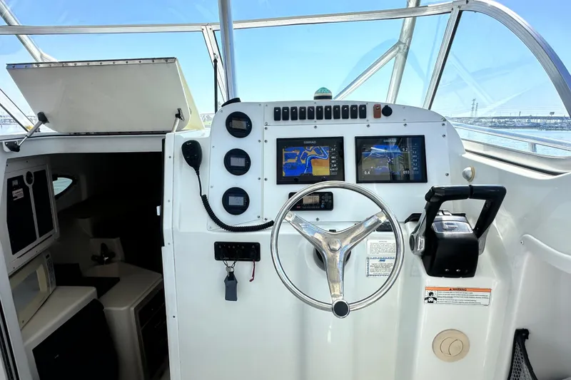 Slide: The Image of 2007 Polar 2700 Walkaround boat helm with navigation screens and steering wheel. - 22