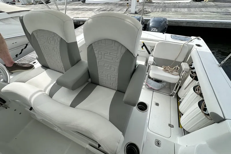 Slide: The Image of 2007 Polar 2700 Walkaround boat interior with cushioned seating and dock view. - 27