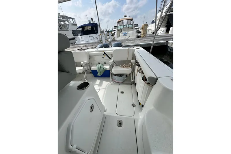 Slide: The Image of 2007 Polar 2700 Walkaround boat interior at marina, featuring seating and storage. - 37