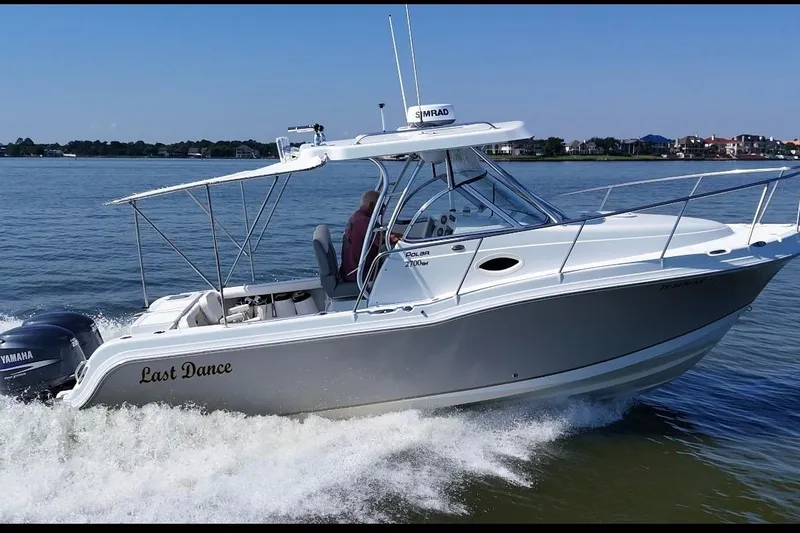 Slide: The Image of 2007 Polar 2700 Walkaround boat cruising on a calm lake with Yamaha engine. - 4