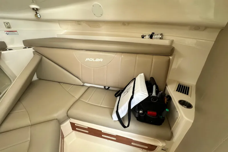 Slide: The Image of Interior of a 2007 Polar 2700 Walkaround boat with beige seating and storage. - 42