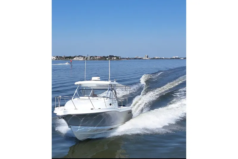 Slide: The Image of 2007 Polar 2700 Walkaround boat cruising on calm water under clear blue sky. - 5