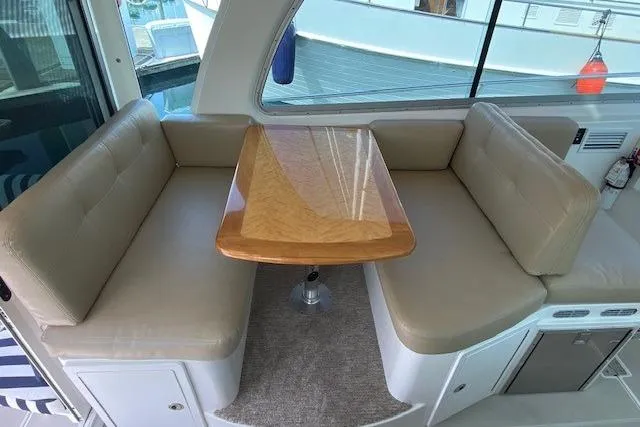 Slide: The Image of Interior seating area of a 2013 Back Cove 34 boat with a wooden table. - 10