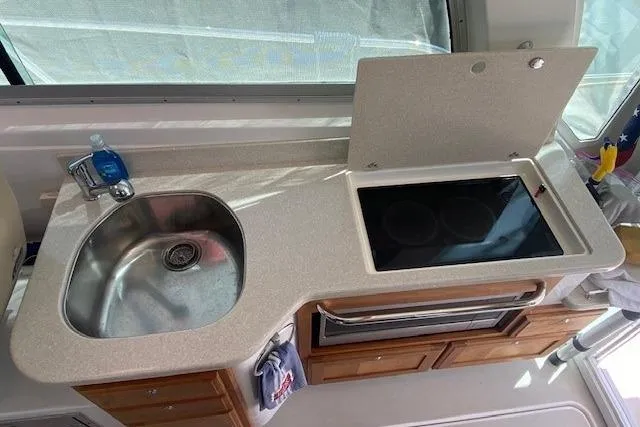 Slide: The Image of Compact kitchen area in a 2013 Back Cove 34 boat with sink and stove. - 12