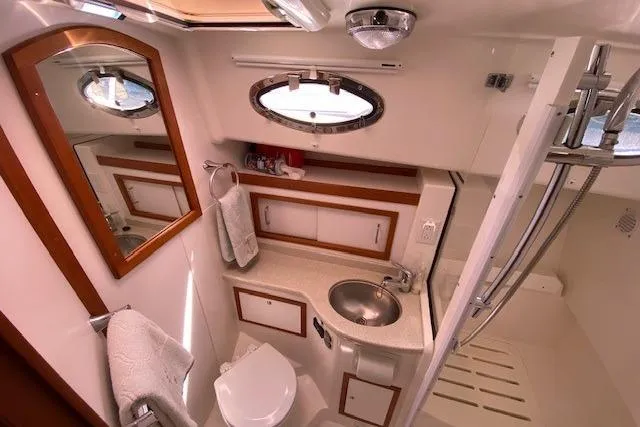 Slide: The Image of 2013 Back Cove 34 yacht bathroom with sink, mirror, and shower area. - 16