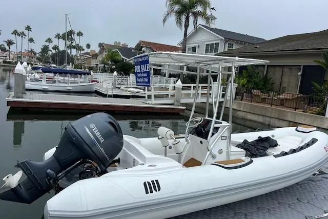 Slide: The Image of 2023 Novurania Como 18 boat with Yamaha engine docked, for sale sign visible. - 16