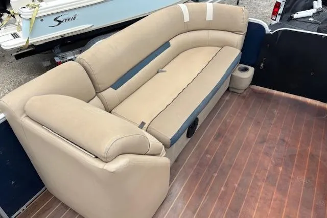 Slide: The Image of 2019 Sweetwater 2286 boat interior with beige seating and wooden flooring. - 11