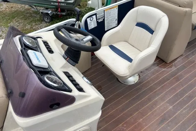 Slide: The Image of 2019 Sweetwater 2286 boat helm with steering wheel and cushioned captain's chair. - 15