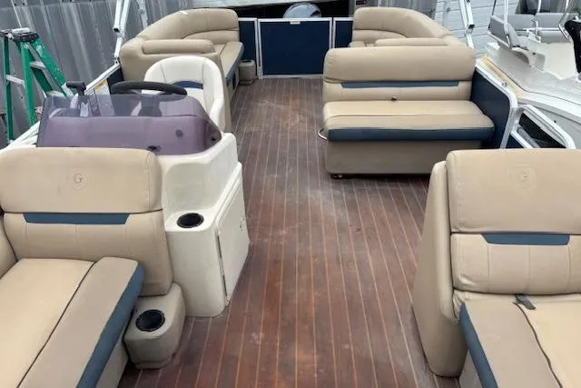 Slide: The Image of 2019 Sweetwater 2286 pontoon boat interior with beige seating and wooden flooring. - 16