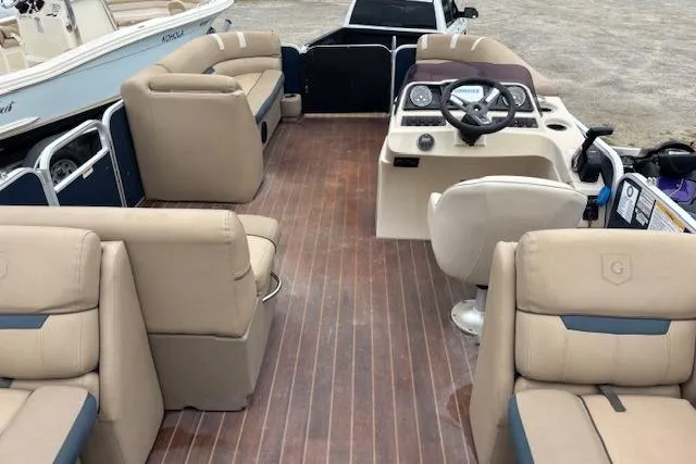 Slide: The Image of 2019 Sweetwater 2286 pontoon boat interior with beige seating and wood-style flooring. - 17