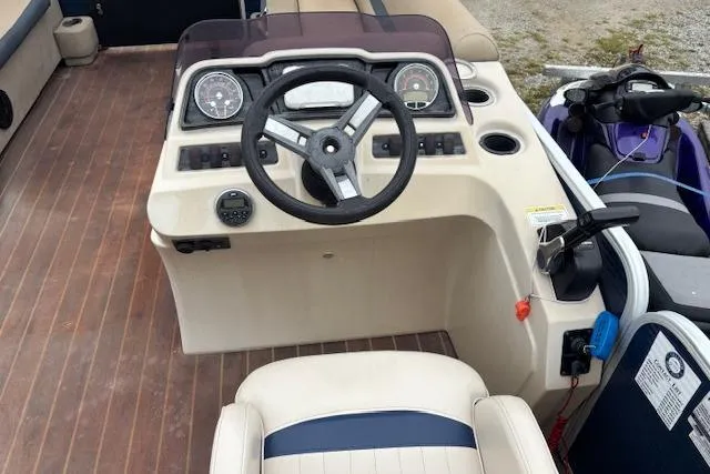 Slide: The Image of 2019 Sweetwater 2286 boat dashboard with steering wheel and controls on wooden deck. - 9