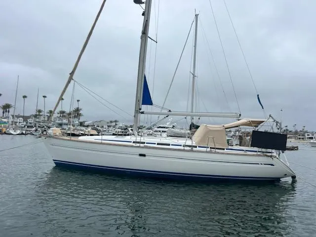 Slide: The Image of Sailboat Bavaria 42 Cruiser 2000 on calm waters, overcast sky, marina background. - 1