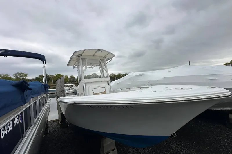 Slide: The Image of 2014 Sportsman Heritage 211 Center Console boat docked under cloudy skies. - 11