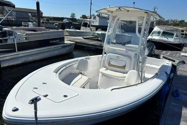 Slide: The Image of 2014 Sportsman Heritage 211 Center Console boat docked at a marina. - 2