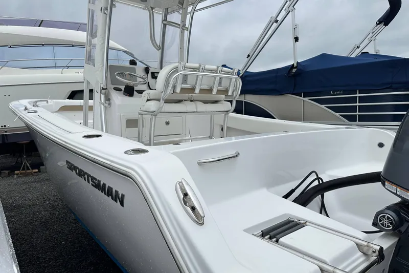 Slide: The Image of 2014 Sportsman Heritage 211 Center Console boat in marina, showcasing sleek design and seating. - 5
