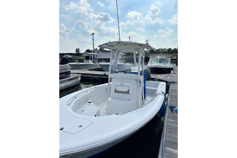 Slide: The Image of 2014 Sportsman Heritage 211 Center Console boat docked at marina under cloudy sky. - 7