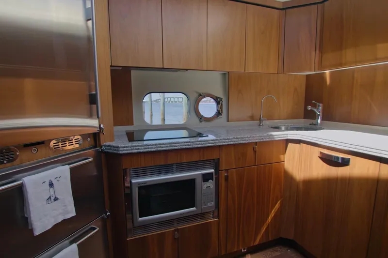 Slide: The Image of Luxurious kitchen interior of 2014 Sunseeker Manhattan 55 yacht with wooden cabinetry and modern appliances. - 17