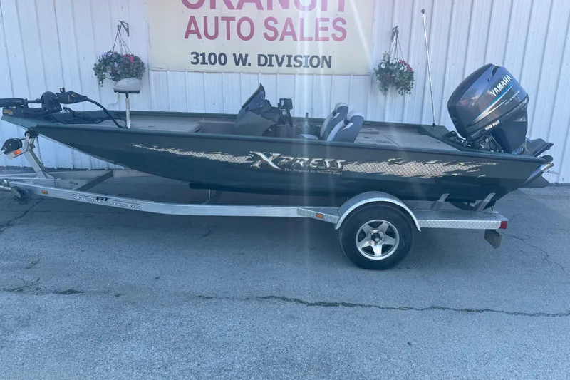 Slide: The Image of 2014 Xpress H18 boat on trailer at dealership, featuring Yamaha outboard motor. - 18