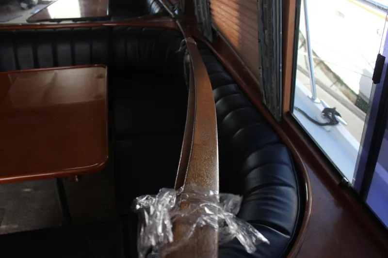 Slide: The Image of Interior of a 1994 Mikelson 64 yacht with leather seating and wooden table. - 29
