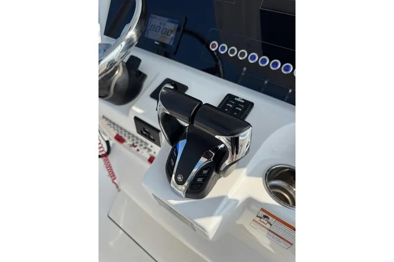 Slide: The Image of 2022 Edgewater 262CC boat console with steering wheel and throttle controls. - 11