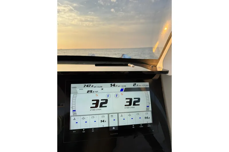 Slide: The Image of Edgewater 262CC 2022 boat dashboard displaying speed and fuel data at sunset. - 13