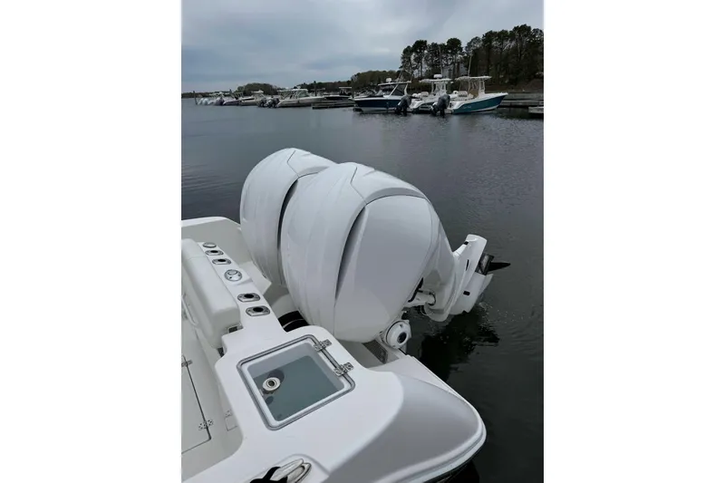 Slide: The Image of 2022 Edgewater 262CC boat with dual outboard engines docked at marina. - 16