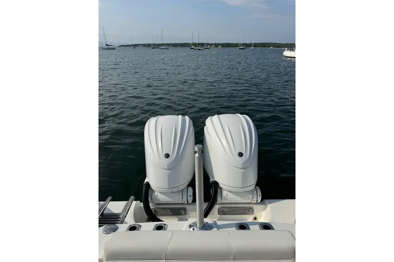 Slide: The Image of 2022 Edgewater 262CC boat with dual outboard motors on a calm sea. - 17