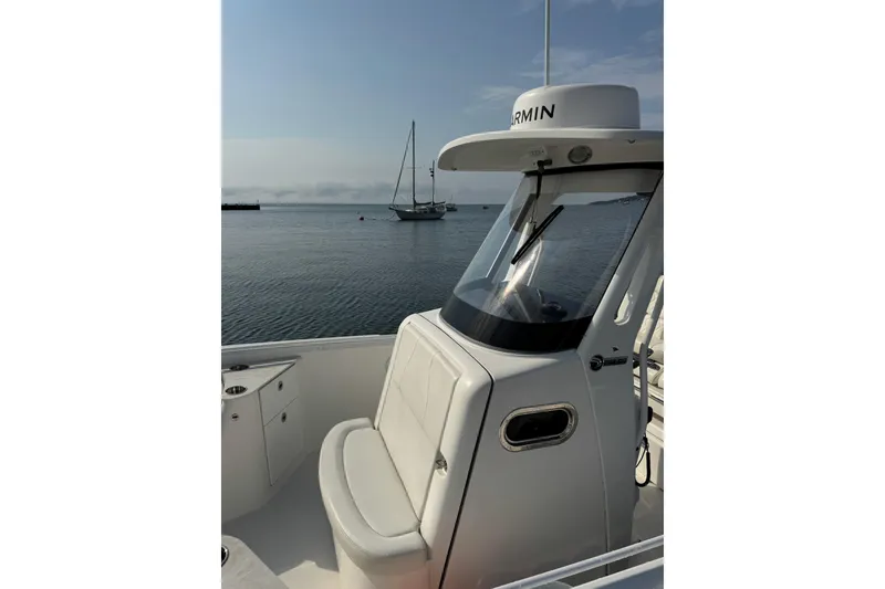 Slide: The Image of 2022 Edgewater 262CC boat with Garmin equipment, docked on calm water. - 22