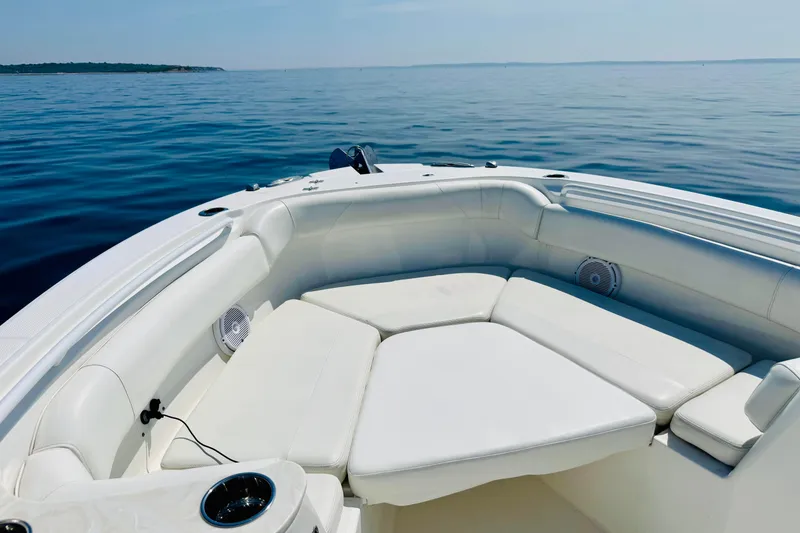 Slide: The Image of 2022 Edgewater 262CC boat interior with white seating, on calm blue water. - 24