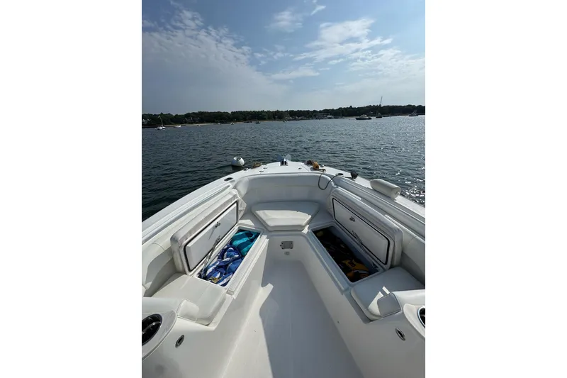 Slide: The Image of Edgewater 262CC 2022 boat interior with open storage compartments on a sunny day. - 25