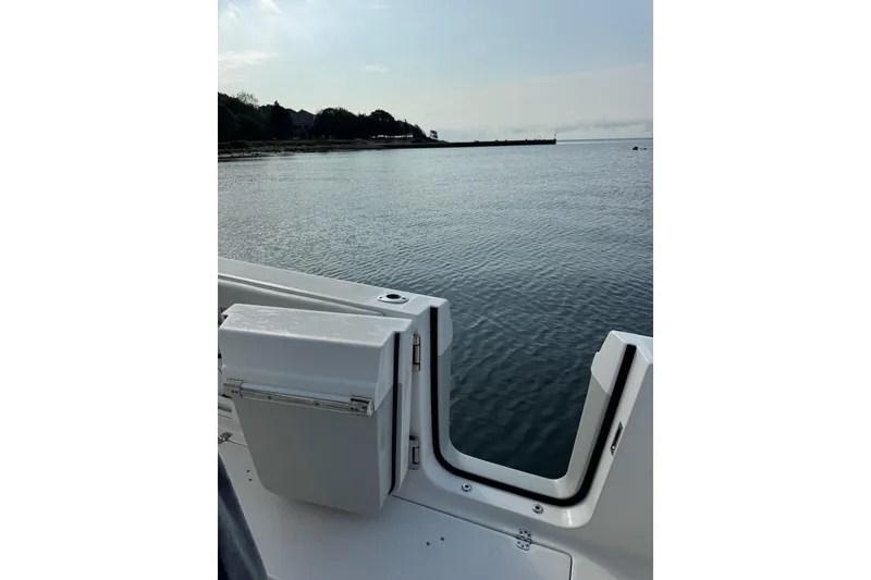 Slide: The Image of Edgewater 262CC 2022 boat on calm water near shoreline, showcasing sleek design. - 27