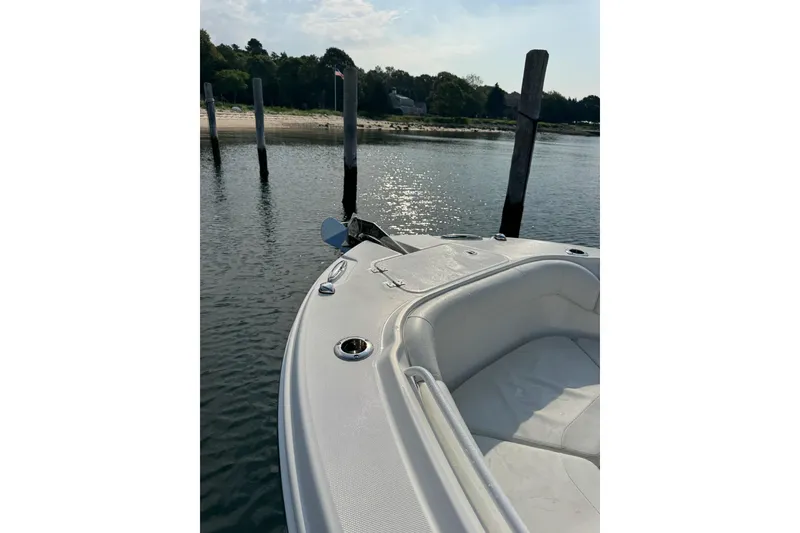 Slide: The Image of 2022 Edgewater 262CC boat docked by a serene waterfront with lush greenery. - 30