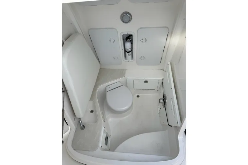 Slide: The Image of Interior of 2022 Edgewater 262CC boat, featuring a compact marine toilet setup. - 32