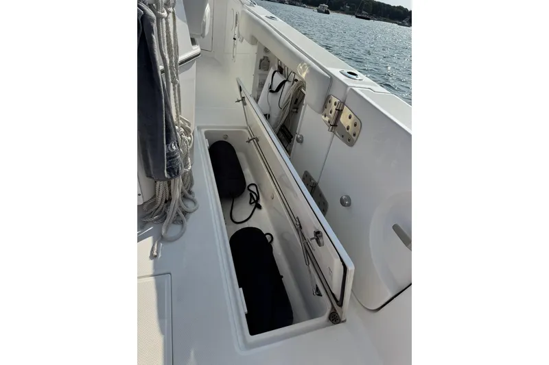 Slide: The Image of 2022 Edgewater 262CC boat storage compartment with ropes and fenders, dockside view. - 34