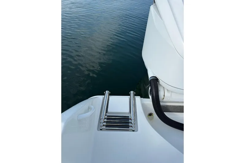 Slide: The Image of 2022 Edgewater 262CC boat ladder and deck by calm water. - 38