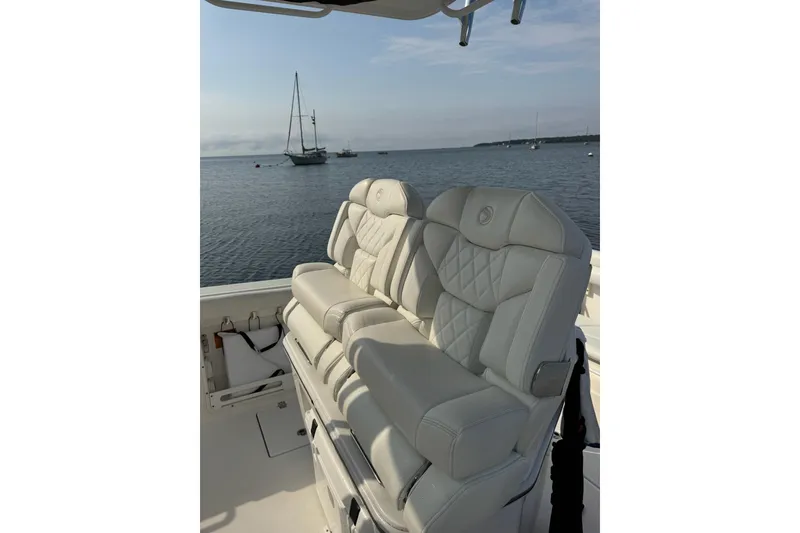 Slide: The Image of Luxurious seating on 2022 Edgewater 262CC boat with ocean view in the background. - 8