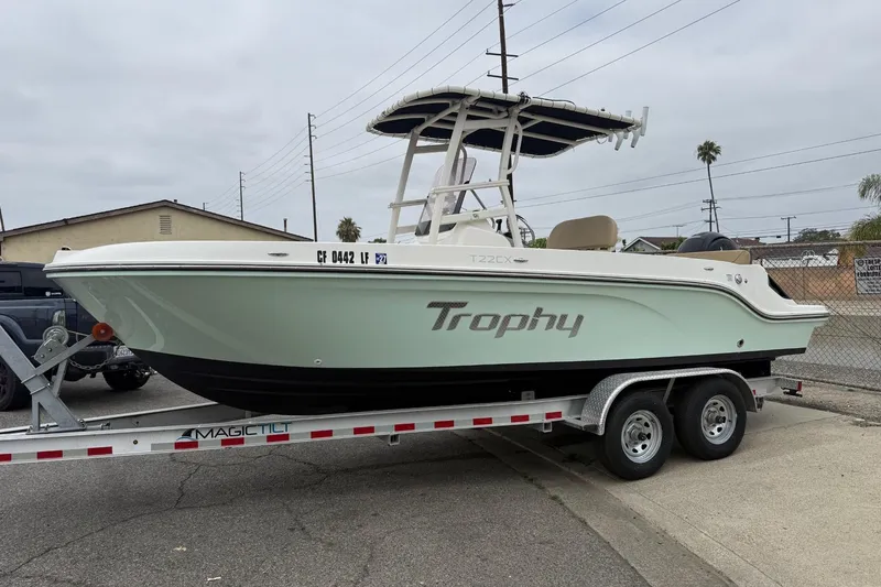 The Image of 2022 Bayliner Trophy T22CX boat on trailer, parked outdoors. - 0