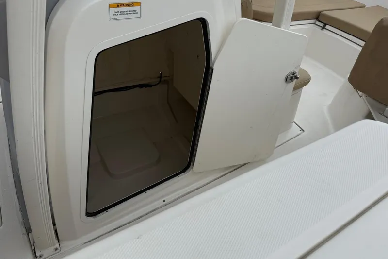 Slide: The Image of 2022 Bayliner Trophy T22CX boat storage compartment with open door. - 11