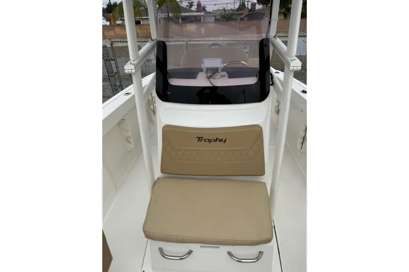 Slide: The Image of 2022 Bayliner Trophy T22CX boat interior with beige seating and windshield. - 13