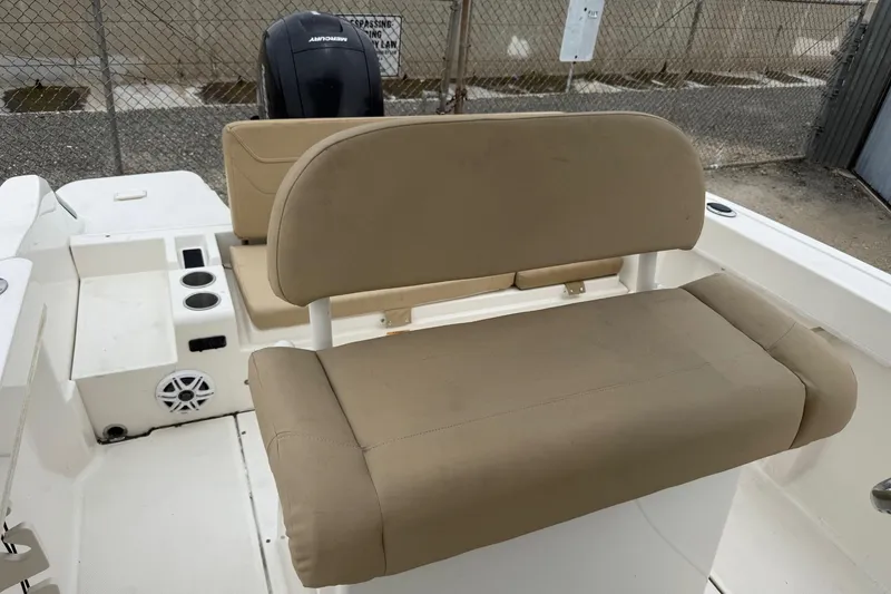 Slide: The Image of 2022 Bayliner Trophy T22CX boat interior with beige seating and Mercury engine. - 16