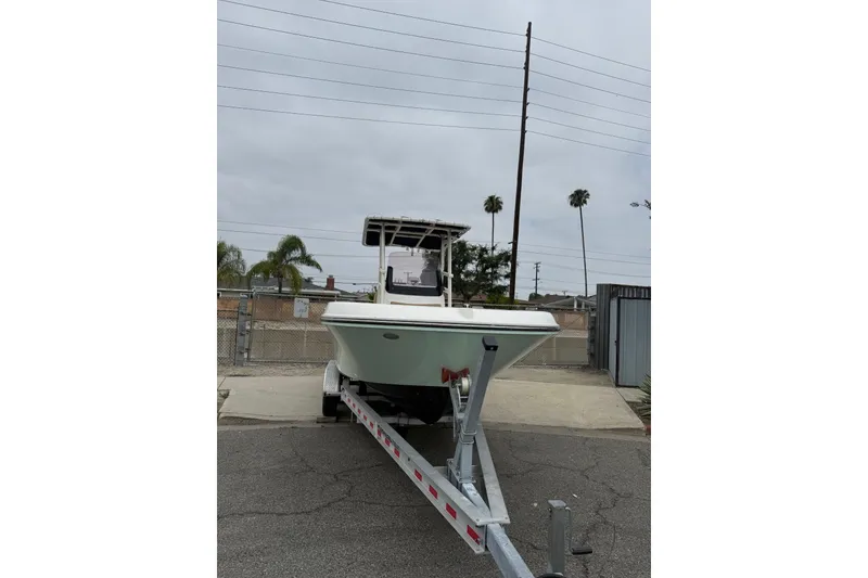 Slide: The Image of 2022 Bayliner Trophy T22CX boat on trailer, parked outdoors. - 19