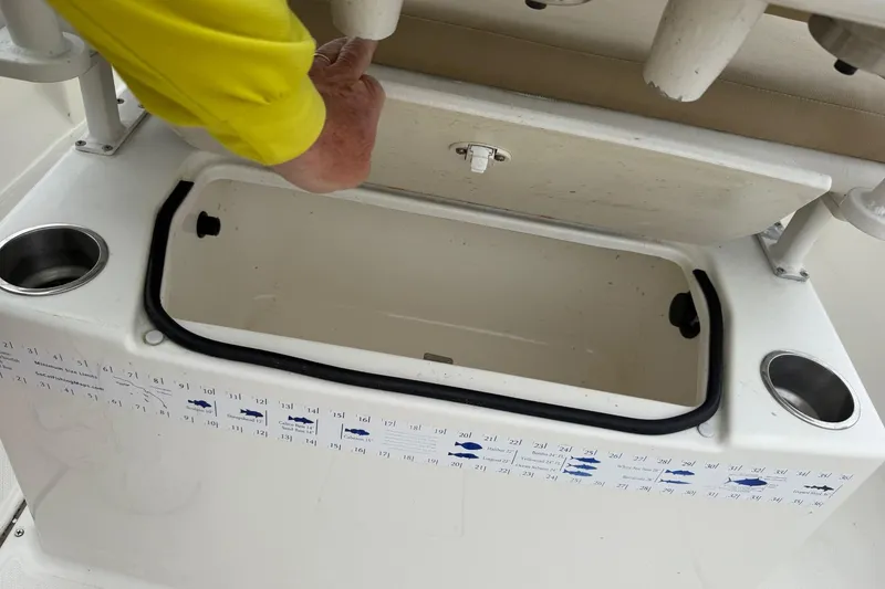 Slide: The Image of Bayliner Trophy T22CX 2022 boat storage compartment with measuring guide and cup holders. - 4