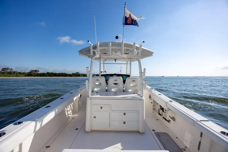 Slide: The Image of 2020 Cobia 350 Center Console boat cruising on open water under clear blue sky. - 13