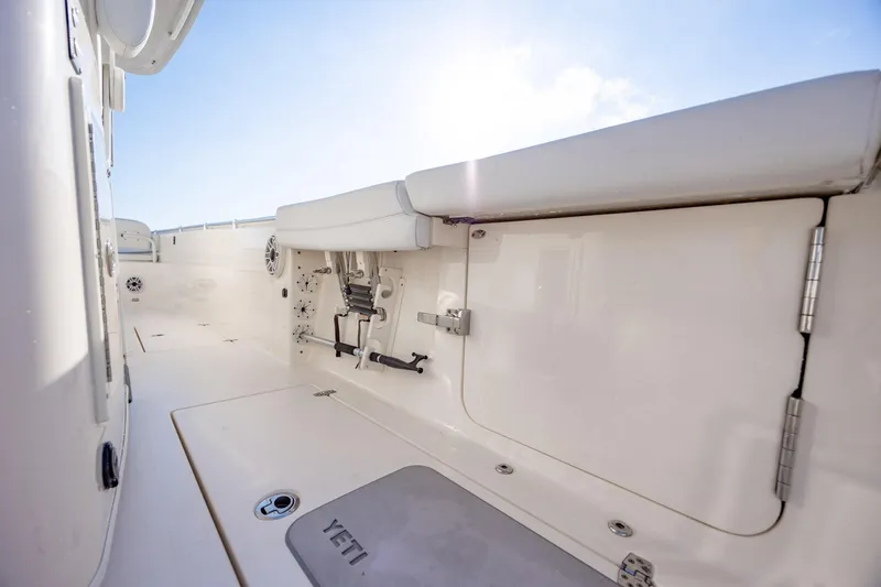 Slide: The Image of 2020 Cobia 350 Center Console boat interior with seating and storage under clear sky. - 24